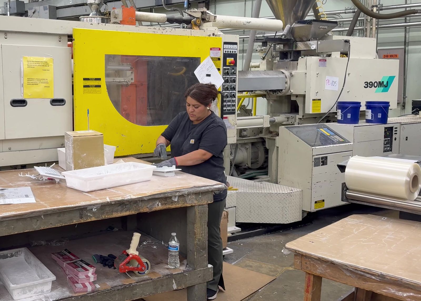 A Burco operator packing parts from injection molding machine 29 into boxes