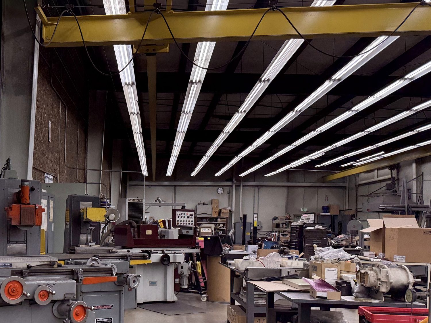 Surface grinders and work benches down the length of the tool room, under the bridge crane